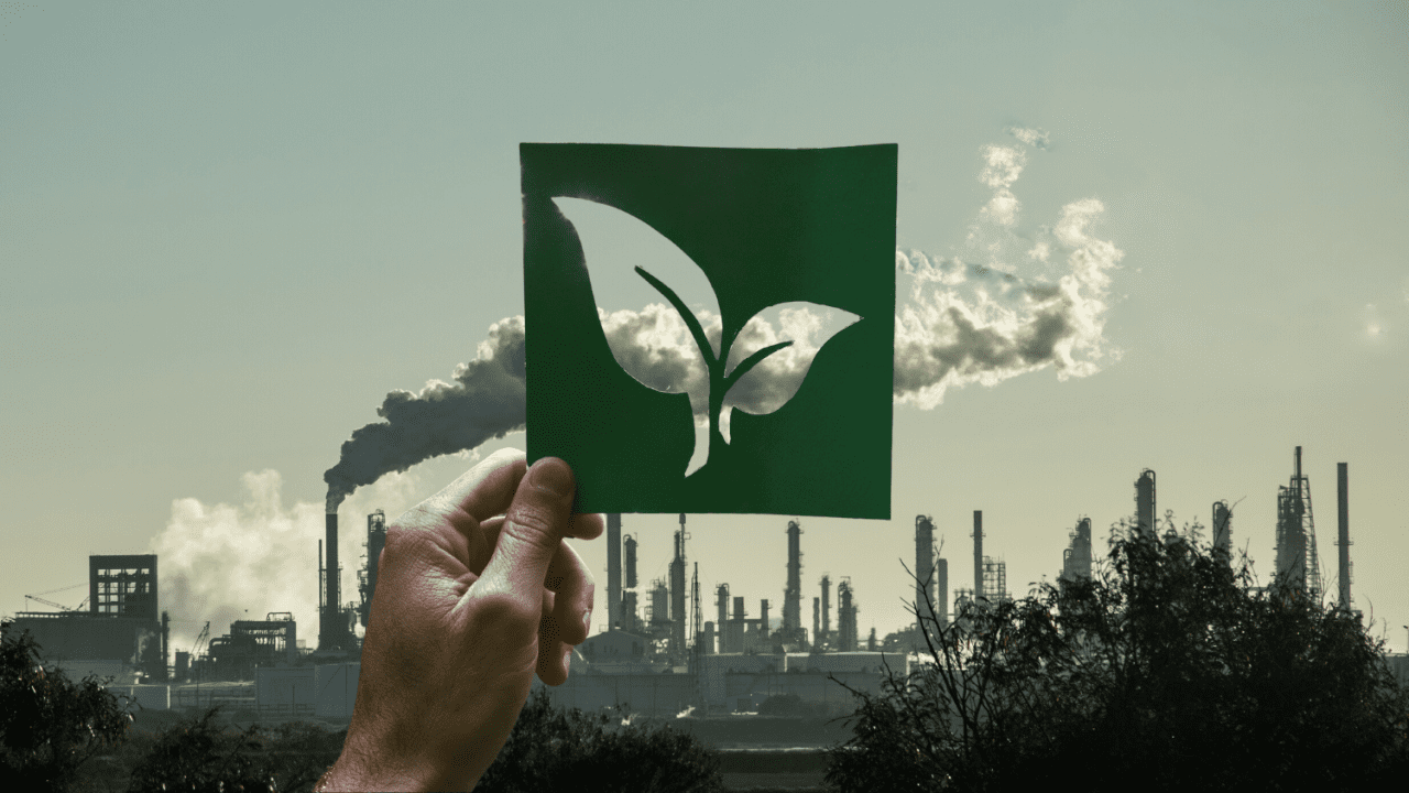 Montage of a hand holding a leaf over a picture of a power plant representing big oil's greenwashing